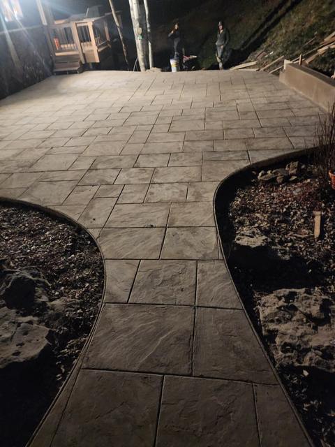 Stamped walkway between curved planter beds